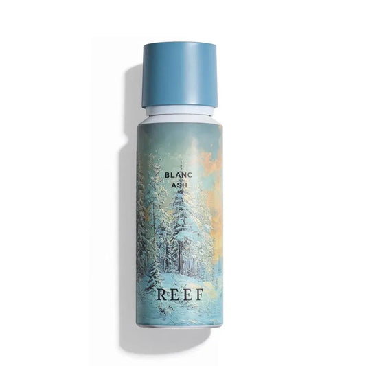 REEF Blanc Ash perfume bottle with snowy forest design and blue cap
